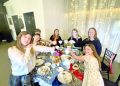 Children raise teacups together around a decorated table during an afternoon tea gathering.