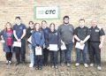 Students and instructors at Greene County CTC pose with certificates in front of a brick wall sign.