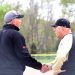 Two baseball coaches shake hands on the field during a game.