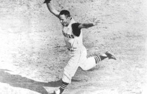Baseball player in a Pirates uniform runs across the field holding his cap in celebration.