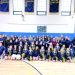 Students, staff, and cheerleaders pose together in a gym during a McOlympics event group photo.