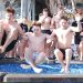 Students jump into a cold pool during a Polar Plunge event while others watch and cheer.