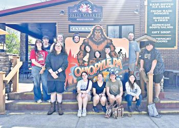 Group of students posing with an Ohiopyle sign outside a market building