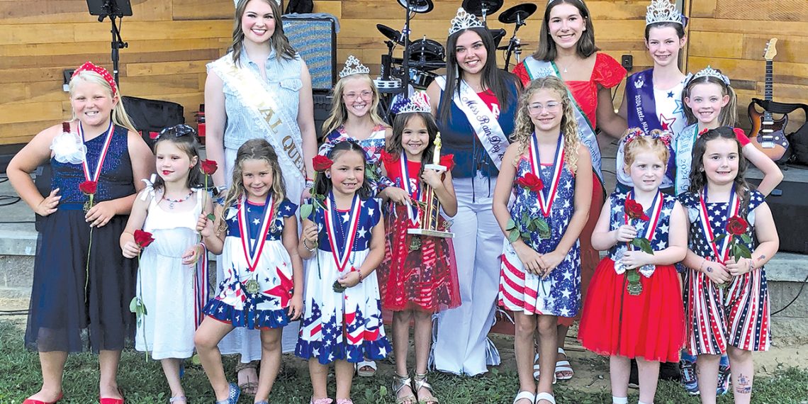 Contestants and pageant royalty pose together during the Little Miss Firecracker Pageant in patriotic attire.