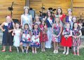 Contestants and pageant royalty pose together during the Little Miss Firecracker Pageant in patriotic attire.