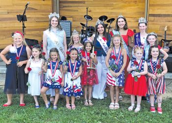 Contestants and pageant royalty pose together during the Little Miss Firecracker Pageant in patriotic attire.