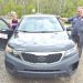 A retired rural mail carrier and mechanic pose beside a Kia Sorento used for mail delivery in Greene County.