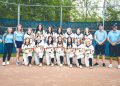 The Carmichaels Lady Mikes softball team and coaches pose together on the softball field for a team photo.