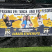 Nikki Gasti Onderko and Bailey Barnyak hold a banner celebrating the Carmichaels High School career strikeout record passing from mother to daughter.