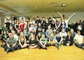 A large group of young participants poses together with balloons and glow sticks during a Black and White Ball celebration.