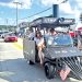 A train themed parade vehicle travels through the Pennsylvania Bituminous King Coal Show parade as spectators watch from the roadside.