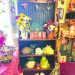 A rustic display inside a country gift shop features floral arrangements, ceramic frogs, decorative signs, and handcrafted home decor.