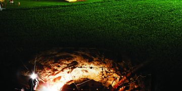 A split image shows a rural farm above an underground coal mine tunnel with a miner, representing the region's agricultural and mining heritage.