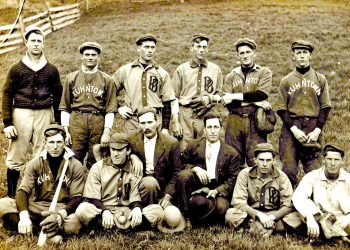 A vintage team photo shows members of the Kuhntown baseball team posing together in uniform on a grassy field.