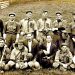 A vintage team photo shows members of the Kuhntown baseball team posing together in uniform on a grassy field.