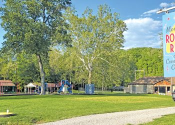 A scenic view of Mon View Park in Greensboro features playgrounds, open grassy areas, large trees, and the Mon View Roller Rink and Community Center sign.