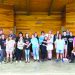 Special Olympics participants, volunteers, and supporters pose together on an outdoor stage during a community picnic.
