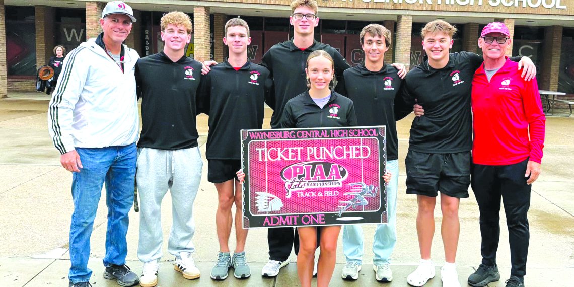Waynesburg Central track and field athletes and coaches pose outside the high school with a sign recognizing their qualification for the PIAA Track and Field Championships.