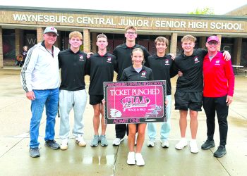 Waynesburg Central track and field athletes and coaches pose outside the high school with a sign recognizing their qualification for the PIAA Track and Field Championships.