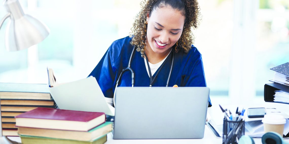 Woman, laptop or medical student books for research, education studying or college learning in university hospital. Smile, happy or healthcare nurse with technology in scholarship medicine internship.