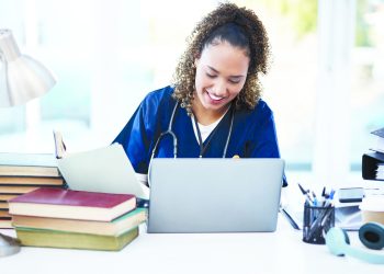 Woman, laptop or medical student books for research, education studying or college learning in university hospital. Smile, happy or healthcare nurse with technology in scholarship medicine internship.