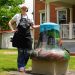 An artist poses beside Greene County's "Coal & Country" painted bell outside the Greene County Historical Society Museum in Waynesburg.