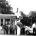 A vintage black and white photo shows customers lined up outside a busy Dari Delite ice cream stand with classic cars parked nearby.