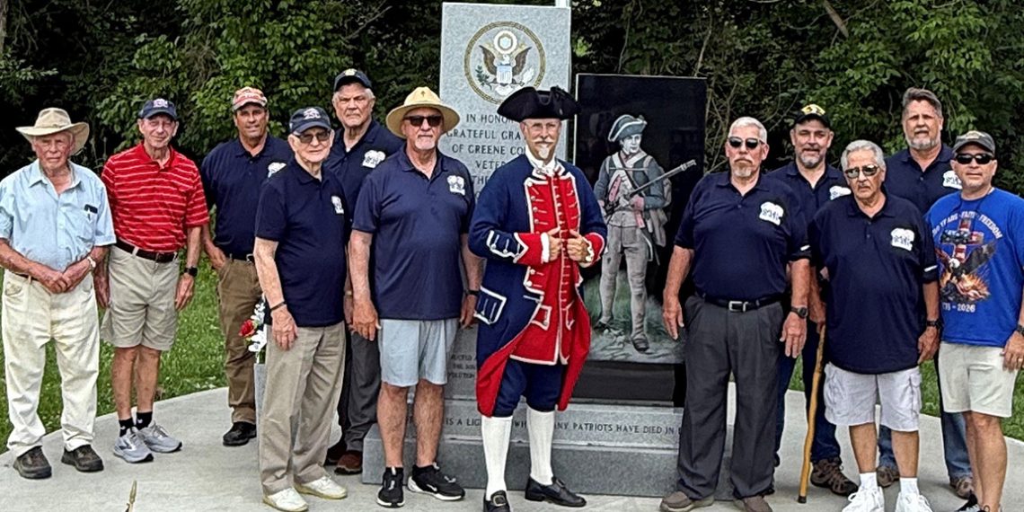 Members of the Fort Jackson Chapter of the Sons of the American Revolution gather at Greene County Veterans Memorial Park with a participant dressed in Colonial era attire.