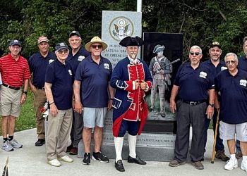 Members of the Fort Jackson Chapter of the Sons of the American Revolution gather at Greene County Veterans Memorial Park with a participant dressed in Colonial era attire.