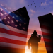 Silhouetted soldier in a spotlight in front of an American flag at sunset with birds in the sky.