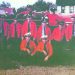 A group of Mount Morris volunteer firefighters poses beside a vintage red fire truck.