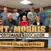 Members of the Mount Morris Sportsman’s Association pose behind a banner celebrating the club’s 75th anniversary.