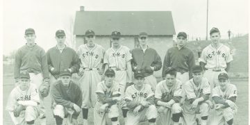 Vintage black-and-white team photograph of baseball players in C.T.H.S. uniforms posing in two rows on a grassy field.