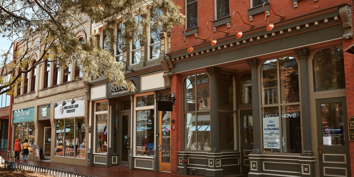 Historic small-town Main Street with restored brick storefronts, local businesses, and tree-lined sidewalks.