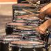 Marching band drummers play a row of drums during a performance.