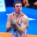 U20 World Wrestling Champion Michael Boyle claps his hands while wearing a red and white USA wrestling singlet on a competition mat.