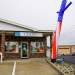 Chapman Insurance Agency's new Waynesburg office features autumn window decorations, a storefront sign, and a tall patriotic inflatable waving figure outside the entrance.