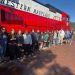 Carmichaels students and a teacher stand beside a red and white Western Maryland Railway locomotive during a fall field trip aboard the Frostburg Flyer.