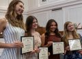 Four smiling Waynesburg University students pose together while holding framed Alpha Lambda Delta honor society certificates.