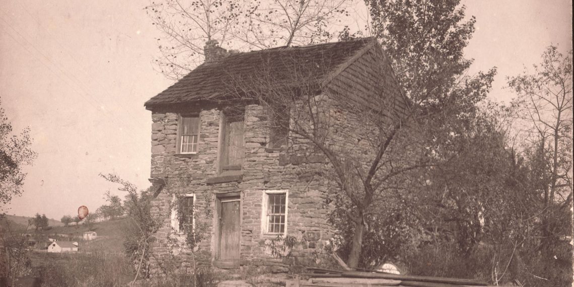 Historic photograph of Captain James Seals' two-story stone house in West Waynesburg, featuring stone walls, wooden doors, and surrounding trees.