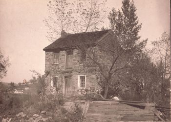 Historic photograph of Captain James Seals' two-story stone house in West Waynesburg, featuring stone walls, wooden doors, and surrounding trees.