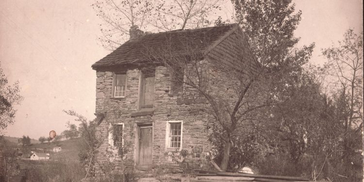 Historic photograph of Captain James Seals' two-story stone house in West Waynesburg, featuring stone walls, wooden doors, and surrounding trees.