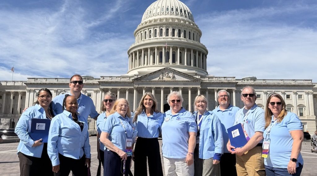 A group of cancer advocates wearing light blue shirts stand together in front of the U.S. Capitol during the American Cancer Society Cancer Action Network's advocacy event in Washington, D.C.